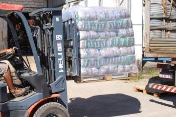 Empilhadeira movimentando cestas básicas paletizadas